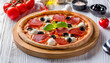 a pizza with black olives and black olives sits on a wooden board.