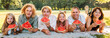 © Soloviova Liudmyla - Big family lying on the picnic blanket in city park under Linden tree during weekend Sunday sunny day, smiling, laughing at camera and eating watermelon. Family values and outdoor activities concept.