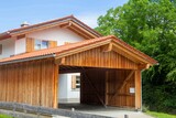 Fototapeta  - Schöner Carport aus Holz vor einem Wohnhaus in alpenländischem Stil