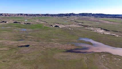 Wall Mural - Landscape with mountain range in Badlands National Park South Dakota showing eroded formations beside mixed-grass prairie American vacation destination to explore, hike and camp