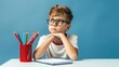 © NovaVision - Boy with Glasses Studying at Desk with Pencils. Generative ai