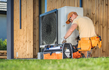 Wall Mural - HVAC Technician Worker Fixing Heat Pump at House