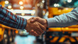© thanakrit - Business handshake at a transport hub, representing successful partnership agreements with a backdrop of vibrant truck lights.