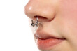 © vladimirfloyd - Closeup of a young serious woman's visage with piercing septum hanging from her nose