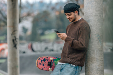 Sticker - young man on the street with mobile phone and skateboard