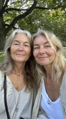 Wall Mural - Two women sitting next to each other in a park