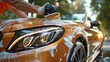 © Fauzi - Detailed view of a car being meticulously buffed and polished outdoors.