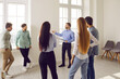 © Studio Romantic - Group of business people chatting after a meeting. Company employees talking in the office and making great decisions. Cowokers listen to their colleague standing in a circle at the working place.