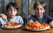 Two boys enjoying a hearty meal of pizza and spaghetti.