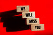 © Emre Akkoyun - We will miss you words written on wooden blocks with red background. Conceptual we will miss you symbol. Copy space for text.