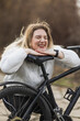 Woman Laughing While Kneeling Down Next to Bike