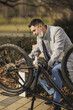 Businessman Fixes Bicycle Chain in Park During Break