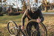 Man in Helmet Inspects His Mountain Bike in a Park