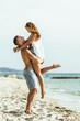 Man Holding Woman on Beach
