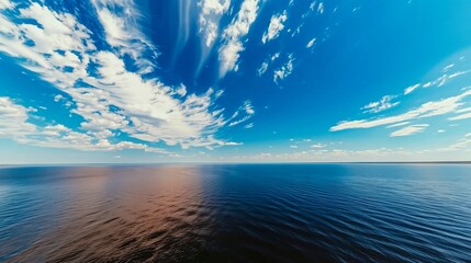 Wall Mural - Sky is blue and the water is calm. The clouds are scattered throughout the sky