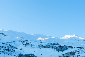 Sticker - Whakapapa ski-field and facilities buildings on shady side of mountain as sun rises on New Zealand