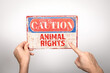 Animal Rights. Metal warning sign in a woman's hand on a white background