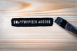 Unauthorized Access. Black paint and paint brush on wood texture background