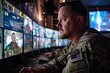 © At My Hat - A man in a military uniform is looking at a computer screen with multiple monitors. He is focused on the screens, possibly monitoring a situation or gathering information