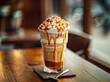 Iced caramel coffee with whipped cream and caramel topping on wooden table