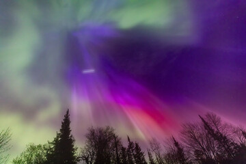 northern lights erupt over minnesota in a dark sky overhead shining rainbow of aurora light as a sat