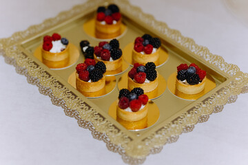 Wall Mural - a set of sweet mini cakes with berries, raspberries, strawberries. sweet buffet. Assorted fruit cakes for holiday