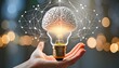 Hand holding drawing virtual light bulb with brain on bokeh background for creative and intelligent thinking