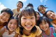 © Igor - Group of happy asian children smiling and looking at camera on blue sky background