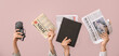 © Pixel-Shot - Female hands with different newspapers, notebook and microphone on color background