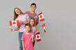 © Pixel-Shot - Happy family with flags of Canada on grey background