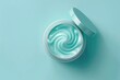 © Barra Fire - Skincare jar with cosmetic anti aging cream swirl texture and lid isolated on pale blue background. Hyaluronic acid moisturizer product