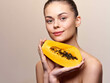 © SHOTPRIME STUDIO - Attractive female holding fresh papaya fruit and making eye contact with camera, tropical healthy lifestyle concept