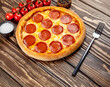 American pizza with pepperoni, mozzarella, and tomato sauce. Pizza on a wooden table