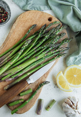 Wall Mural - Fresh green asparagus lies on a wooden cutting board 