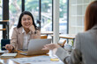 © Surachai - Two Asian businesswomen working Creative discussion in office using laptop and tablet, business concept