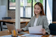© Surachai - Asian business woman working In office using laptop and tablet, business concept