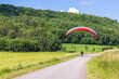 Paraglider on a country road in a rural landscape