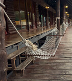 Fototapeta Koty - A hammock hangs near a wooden house