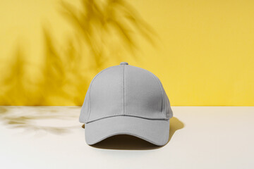 Poster - Baseball hat against yellow background in studio