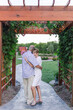 Elderly couple sharing a tender moment under a lit wooden arch