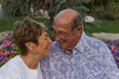 Close-up of a joyful elderly couple laughing in a flower garden