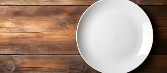 Poster - Top view of a white ceramic plate placed on a wooden background and there is ample copy space in the image