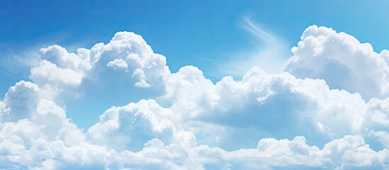 Poster - Background copy space image of a sky filled with fluffy white clouds against a vibrant blue backdrop