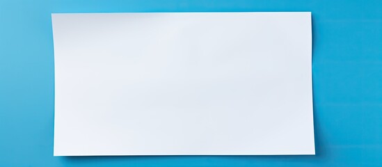 Fototapete - A white sheet of paper is placed on a blue background providing ample copy space for text The image showcases a print design concept