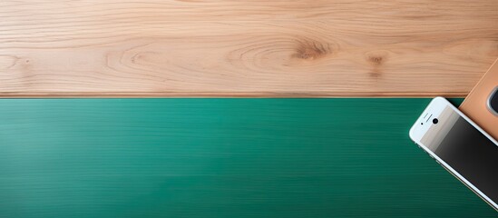 Sticker - A top view of a wooden desk with a green screen smartphone and a paper coffee cup providing ample copy space in the image