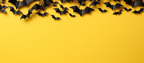 Poster - A top view image of a Halloween banner featuring black paper bats on a yellow and white background with a horizontal orientation and plenty of copy space