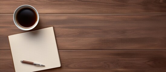Fototapete - Top view of a wooden office desk table with a blank notebook page a pen and a cup of coffee The image has copy space and is captured in a flat lay style