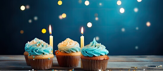 Aufkleber - A festive birthday card features a beautifully decorated muffin with burning candles set against a captivating blue board background Copy space available