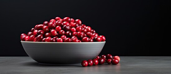 Canvas Print - a bowl of fresh cranberries sits on a dark grey table leaving room for text in the image. creative b