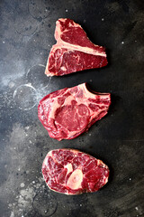Wall Mural - Raw organic marbled beef steaks : ossobuko, rib eye ( cowboy ) , T - bone. Top view with copy space.
